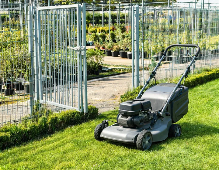 Walk-behind mower beside a narrow grounds access gate